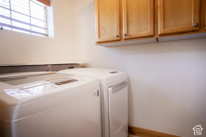 Wall-mounted wood cabinetry providing overhead storage and horizontal window with blinds
