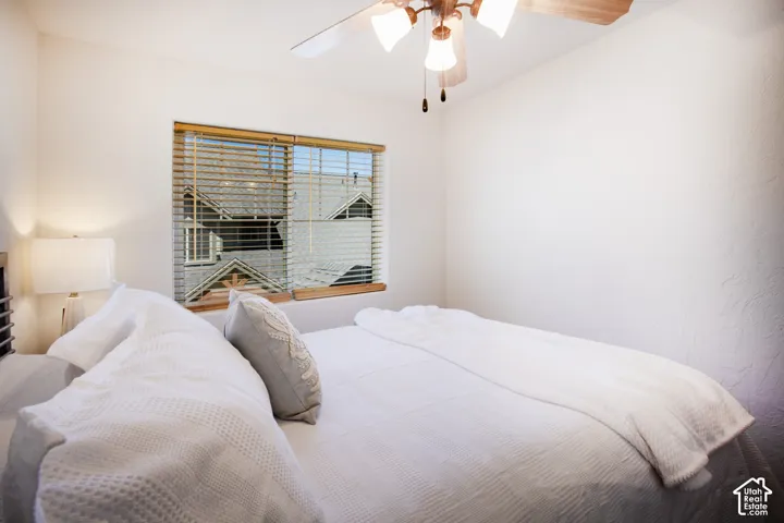Room featuring a ceiling fan with integrated lighting and a window with horizontal slat blinds