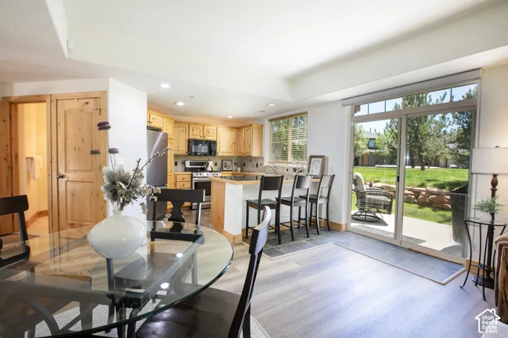 Kitchen featuring light wood cabinetry, stainless steel appliances, and a tiled floor inlay
