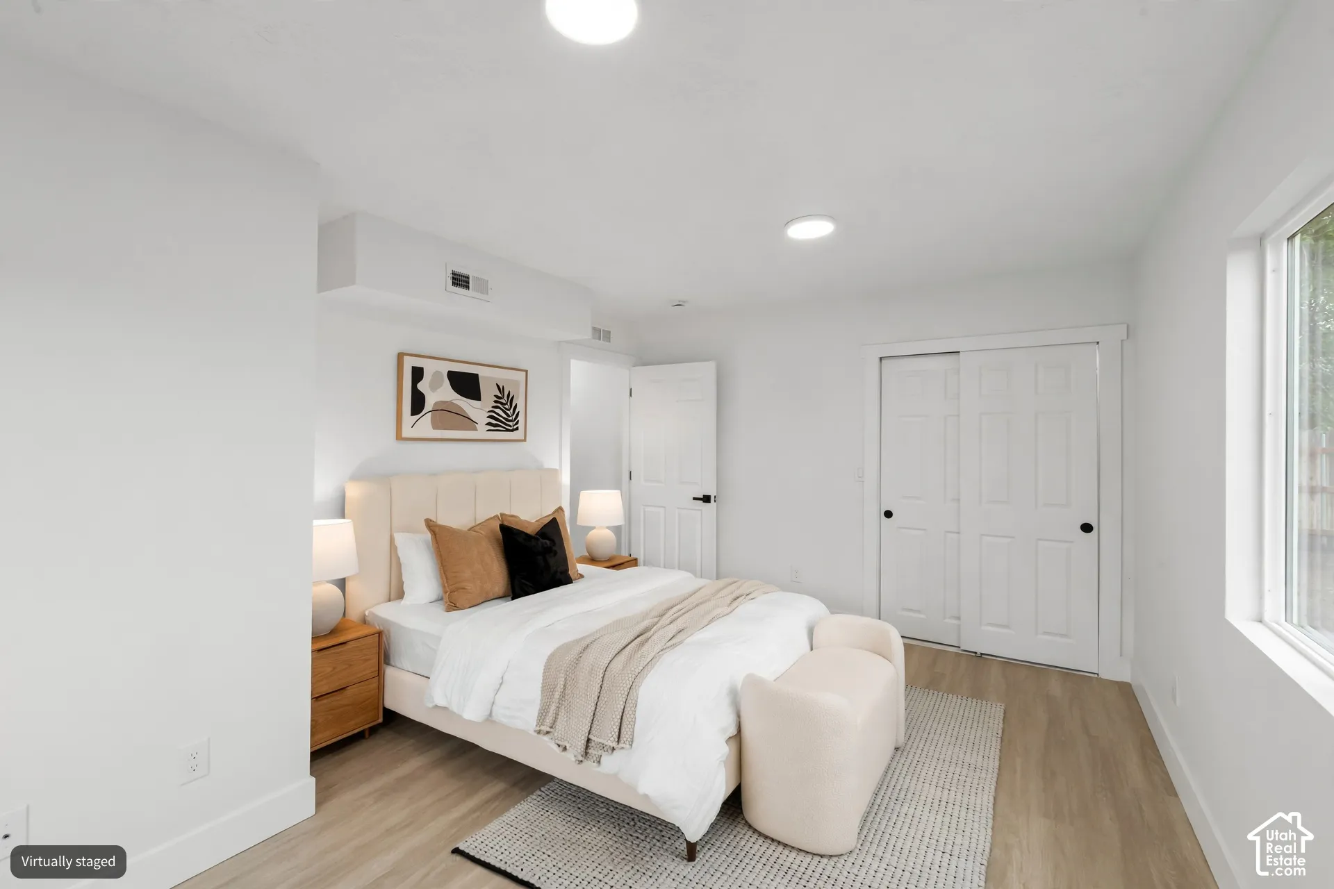 Neutral interior featuring wood-finish flooring, recessed lighting, and a double-door closet with black hardware