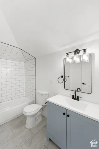 Bathroom featuring a vanity with a white countertop and matte black fixtures, rectangular framed mirror, tub surround with white subway tile, and wood-finish tile flooring