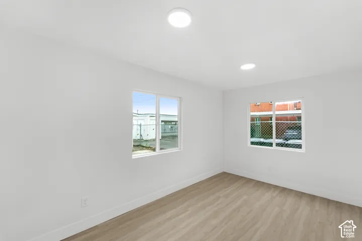 Interior space featuring wood-finish flooring, two dual-pane vinyl windows, and recessed ceiling lighting