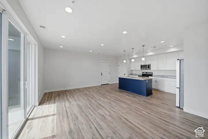 Open concept living area featuring wood-finish flooring and recessed lighting
