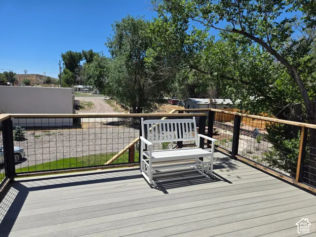 Composite deck featuring a wire-mesh railing system, natural wood-finish top rail, and black metal posts