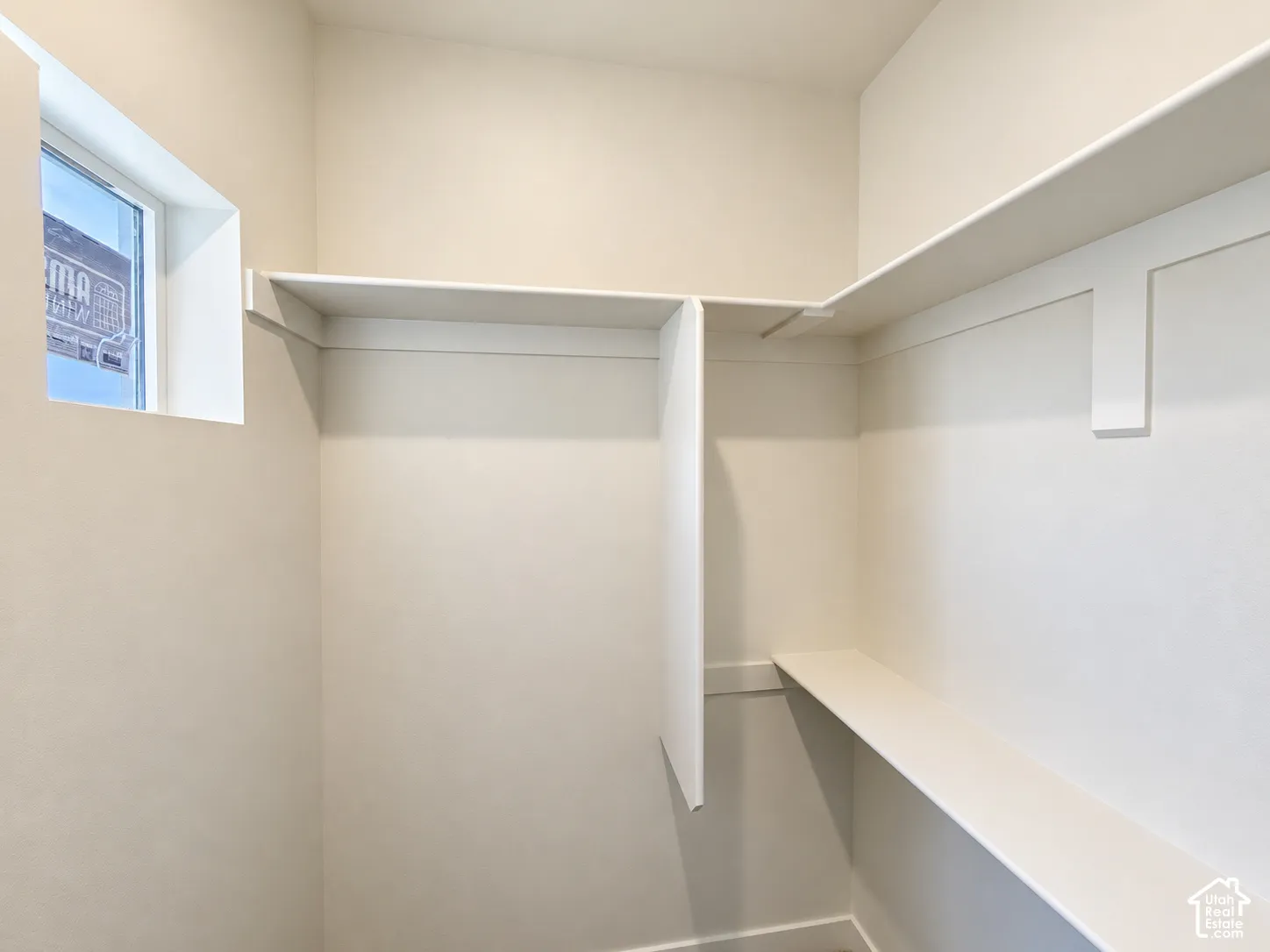 Built-in white shelving, integrated wall partitions, and natural light from a window