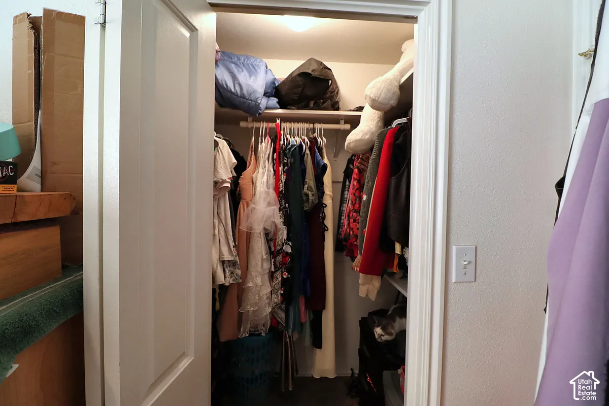 Reach-in closet featuring white paneled double doors and built-in shelving with an integrated hanging rod