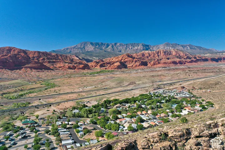 Aerial perspective featuring expansive mountain range backdrop and desert landscape