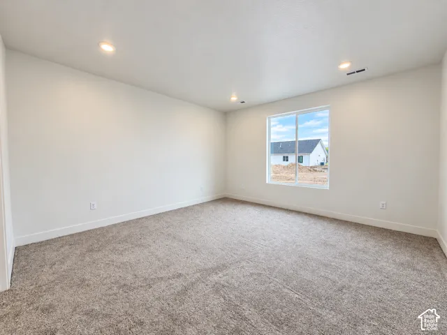 Neutral interior featuring wall-to-wall carpeting, recessed ceiling lighting, and a dual-pane sliding window
