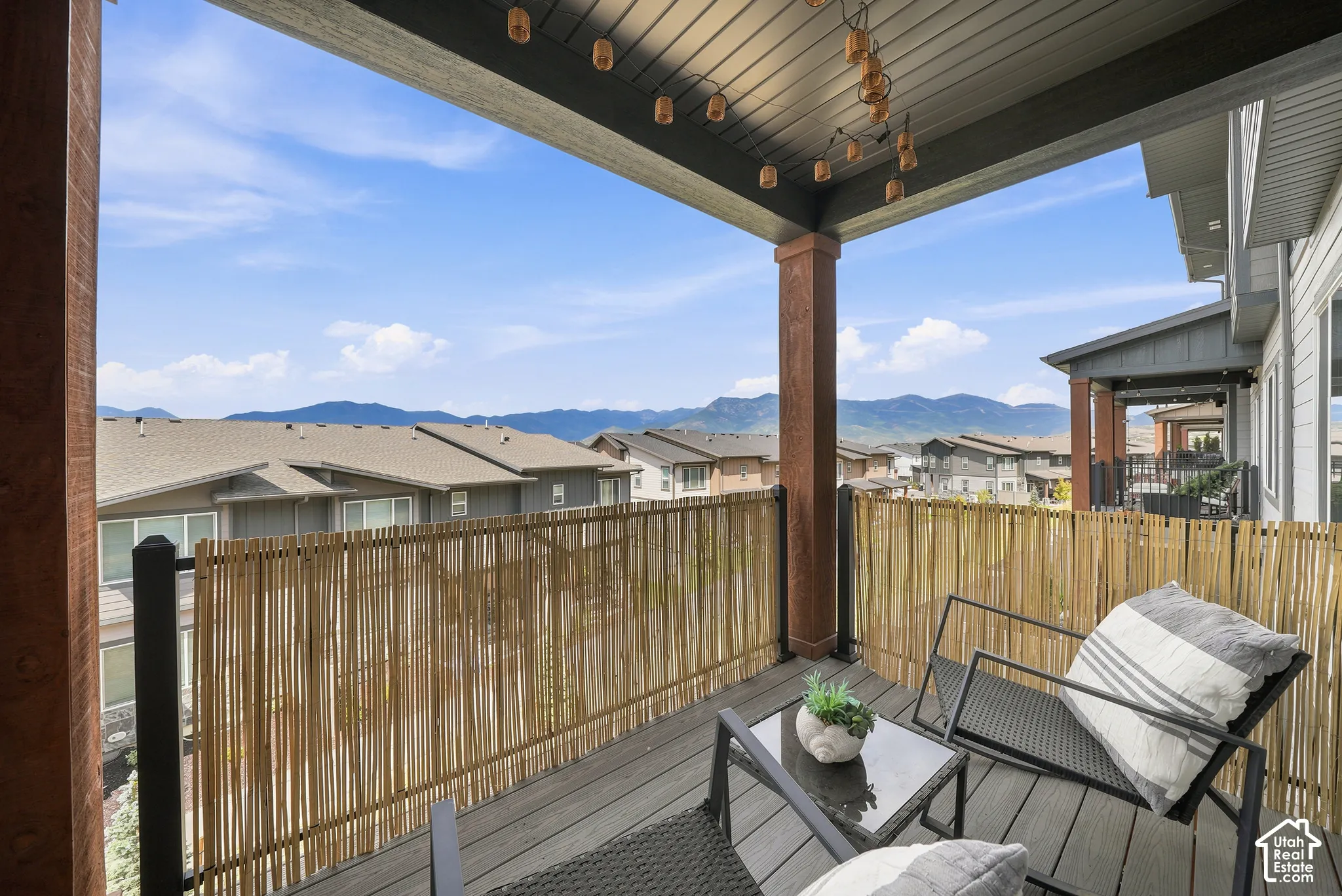 Covered balcony featuring wood-finish flooring, exposed support columns, and mountain scenery