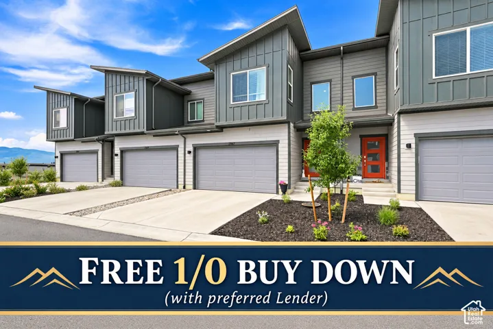 Contemporary multi-unit exterior featuring vertical metal siding, horizontal lap siding, attached garages, and a mountain backdrop