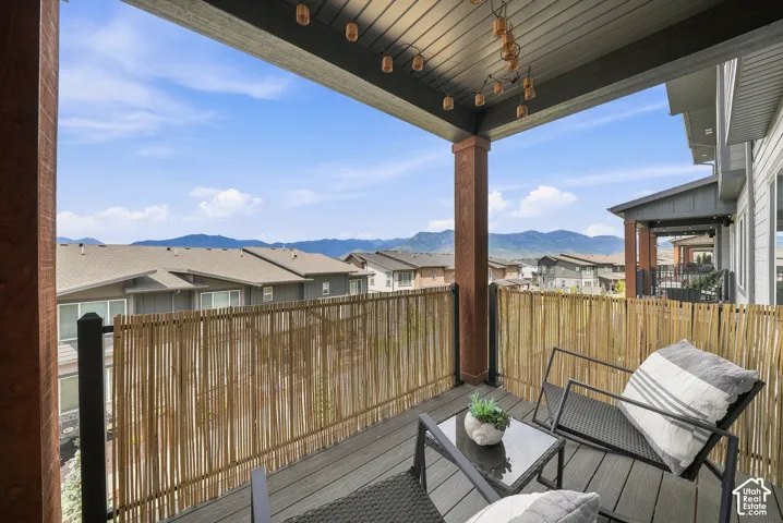 Covered balcony featuring wood-finish flooring, exposed support columns, and mountain scenery