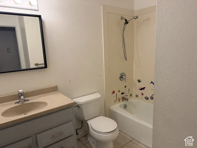 Bathroom featuring a vanity with an integrated basin, a multi-drawer storage cabinet, a wall-mounted mirror, and a tub-shower combination with a detachable showerhead