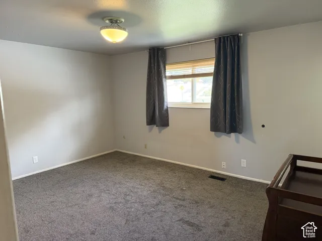 Neutral-toned interior space featuring wall-to-wall carpeting and a ceiling-mounted semi-flush light fixture