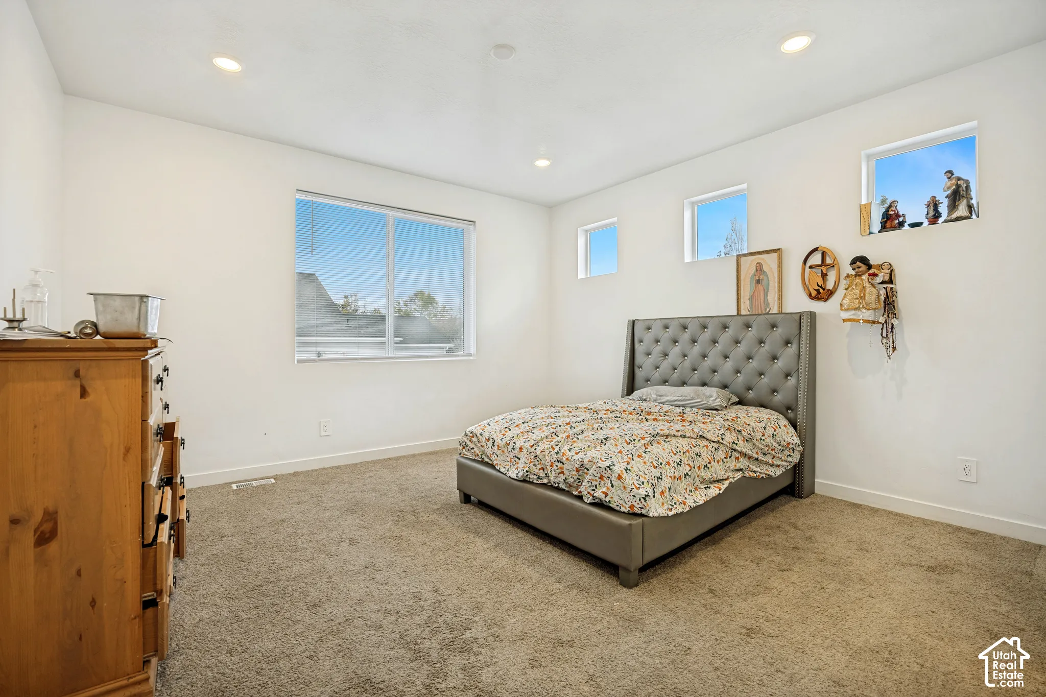 Neutral-toned carpeted flooring, recessed ceiling lighting, and multiple windows including two high-set clerestory-style windows