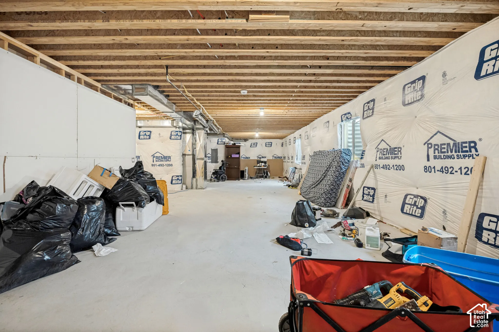 Unfinished lower level featuring exposed wood joist ceilings, concrete flooring, and insulated wall paneling