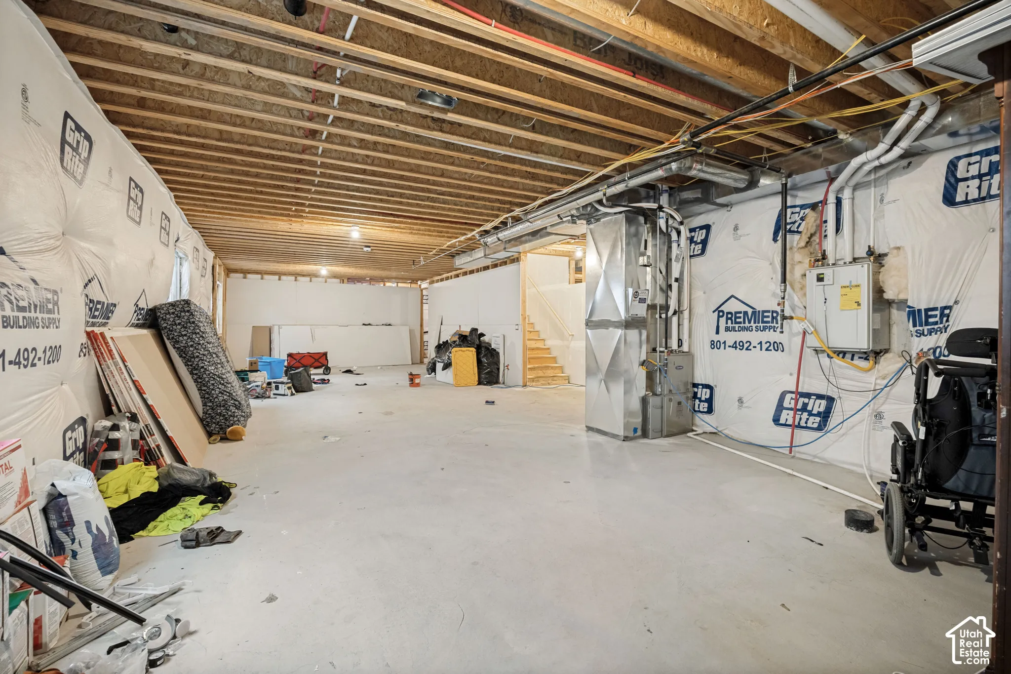 Unfinished lower level featuring concrete flooring, exposed wood ceiling joists, insulated foundation walls, and a mechanical system with metal ductwork