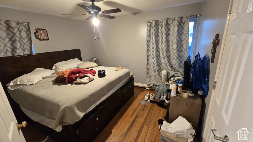 Room featuring wood-finish flooring and a ceiling fan with integrated lighting