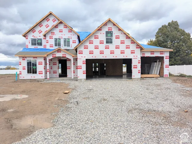 Two-story residential new construction featuring a multi-gabled roofline, an attached three-car garage, and installed double-pane windows