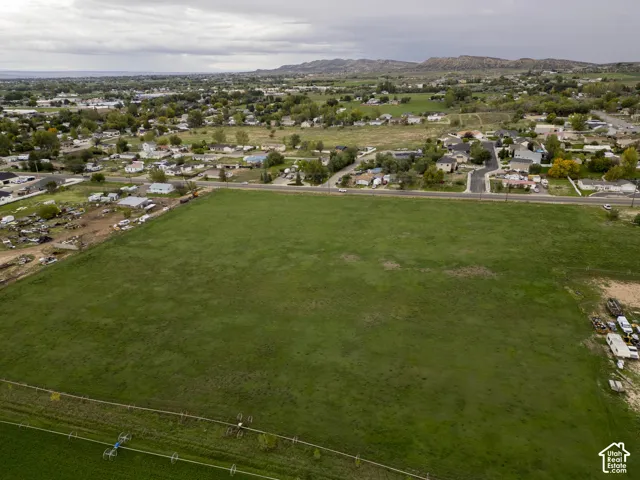 Expansive open lot featuring level topography, perimeter fencing, and mountain range scenery
