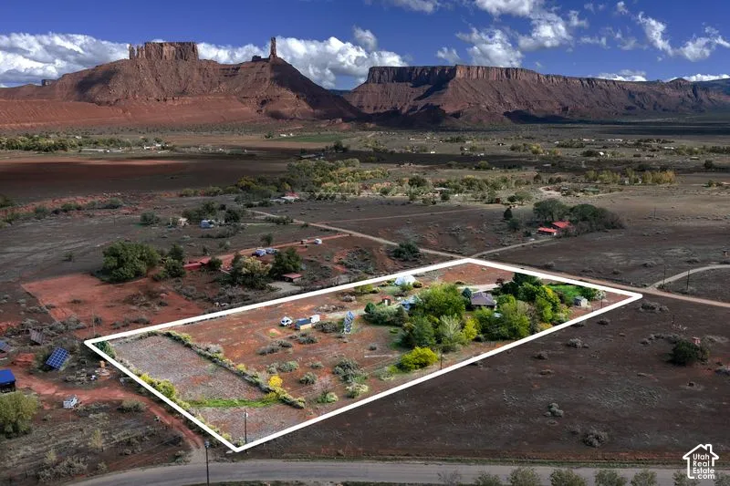 Expansive parcel featuring mature trees, desert landscaping, and prominent red rock mountain scenery