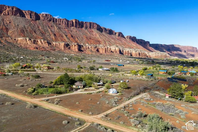 Expansive lot featuring mature trees, desert landscaping, a geodesic dome structure, and mountainous rock formation scenery