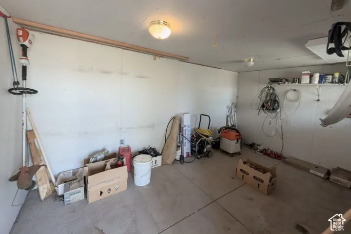 Enclosed storage space featuring concrete flooring, finished wall panels, and ceiling-mounted dome lighting
