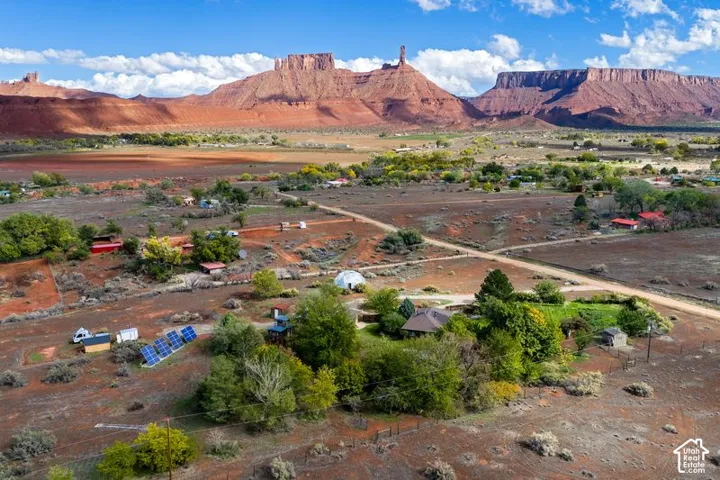 Expansive acreage featuring prominent red rock mountain scenery, dedicated solar panel array, and a secondary dome structure
