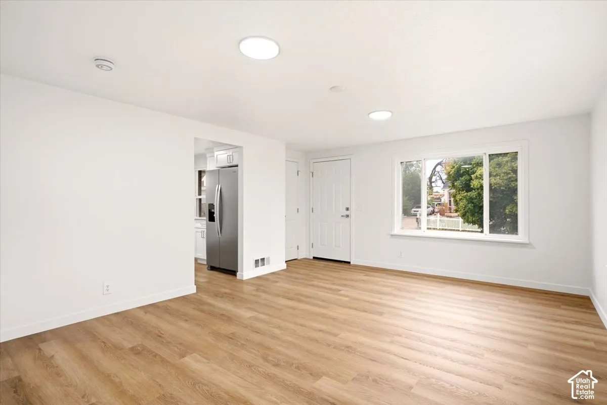 Interior room featuring wood-finish flooring, recessed lighting, a large window, and a multi-panel exterior door