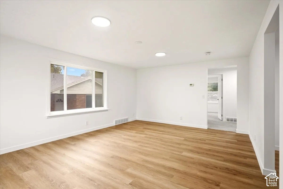 Living area featuring wood-finish flooring, large picture window, and recessed ceiling lighting