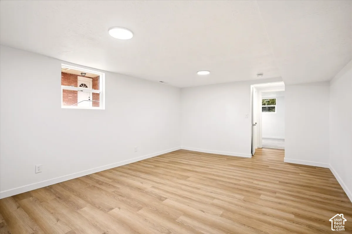 Neutral interior space featuring wood-finish flooring, recessed lighting, and multiple horizontal windows