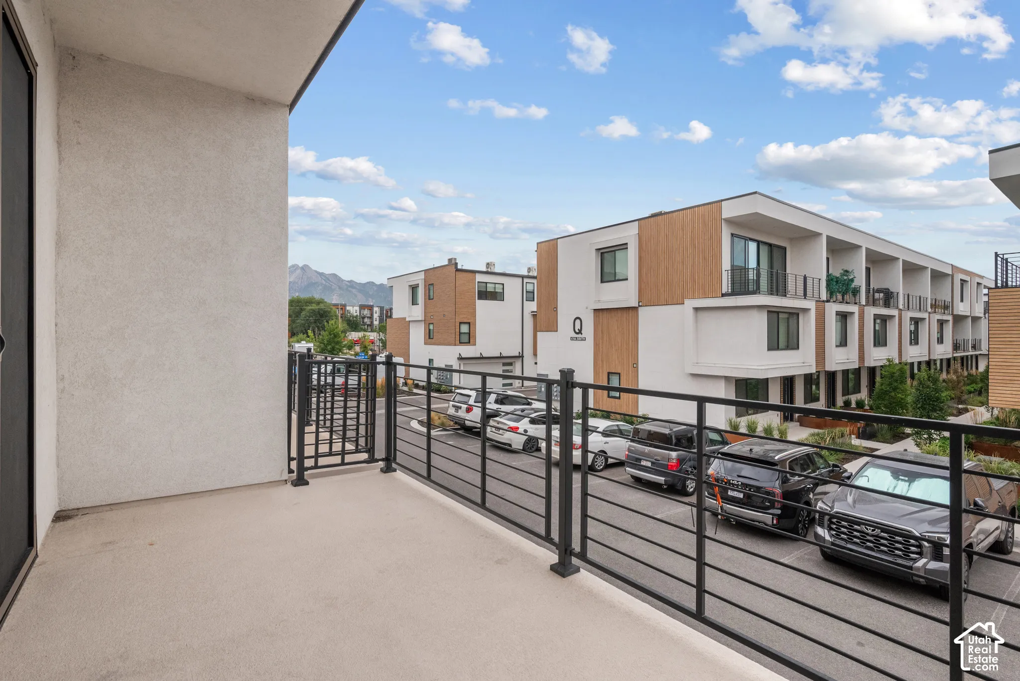 Covered balcony featuring concrete flooring and black metal railing