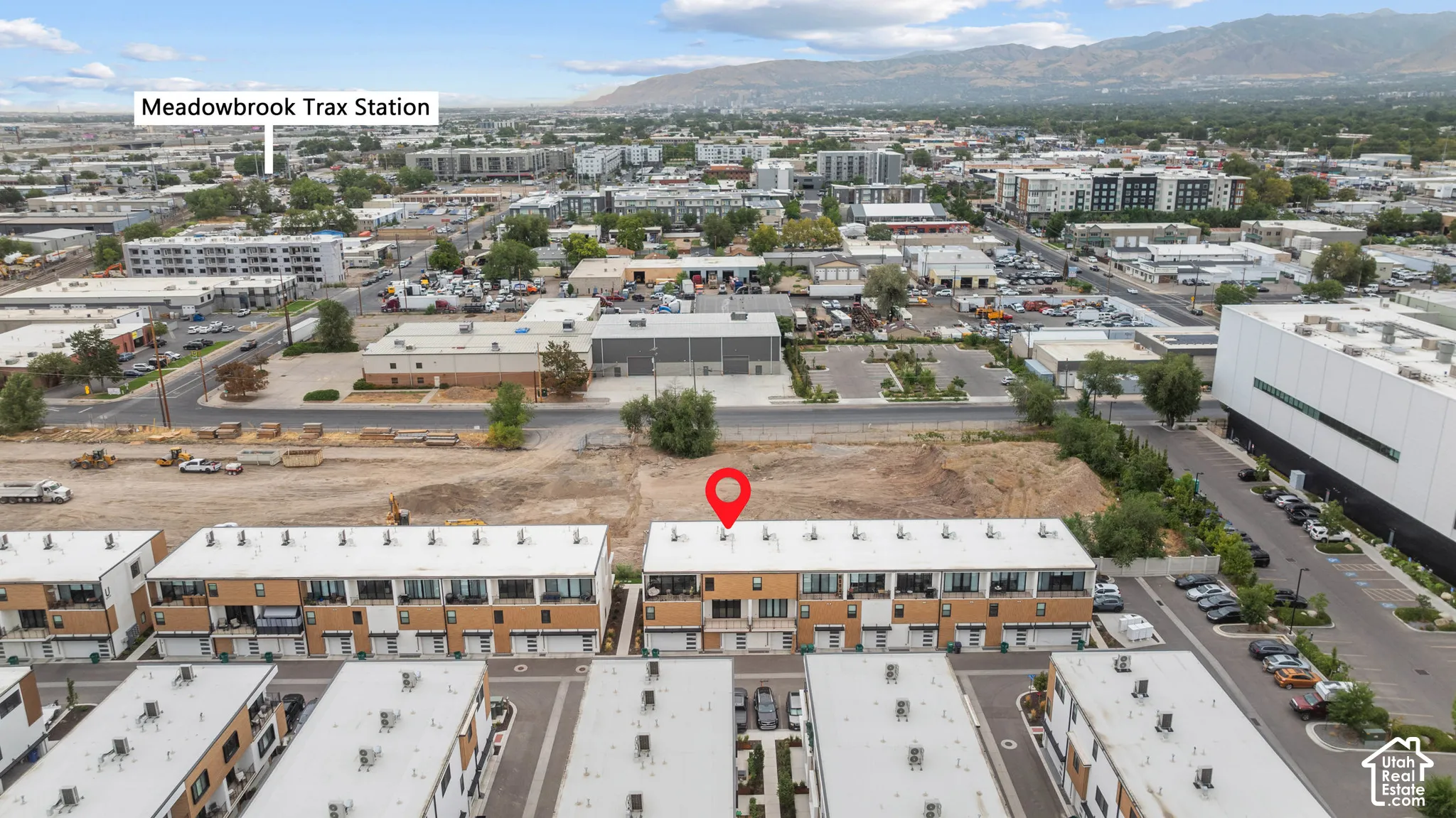 Multi-level townhome featuring a modern facade, attached garage, private balconies, and mountain backdrops