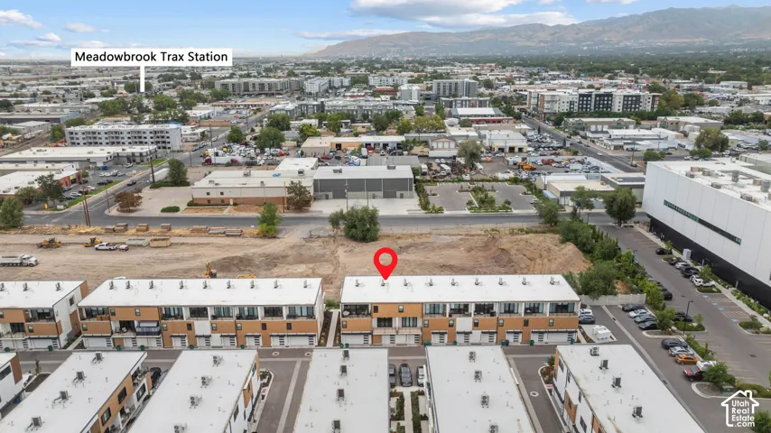 Multi-level townhome featuring a modern facade, attached garage, private balconies, and mountain backdrops