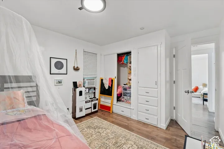 Wood-finish flooring, white-painted interior doors, and built-in closet cabinetry featuring four pull-out drawers