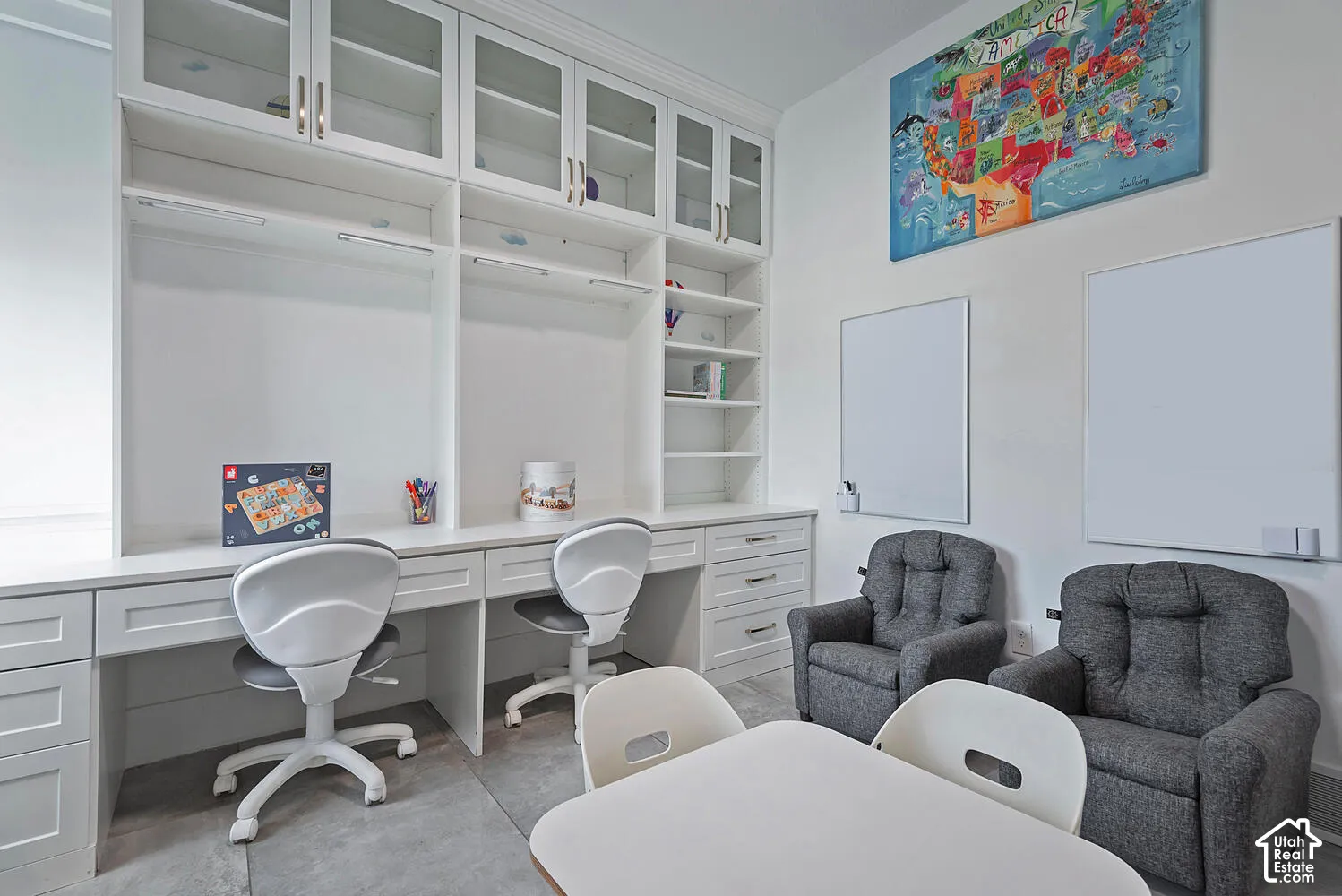 Built-in floor-to-ceiling cabinetry, extended desk surface with integrated storage drawers, open display shelving, and glass-front upper cabinet doors