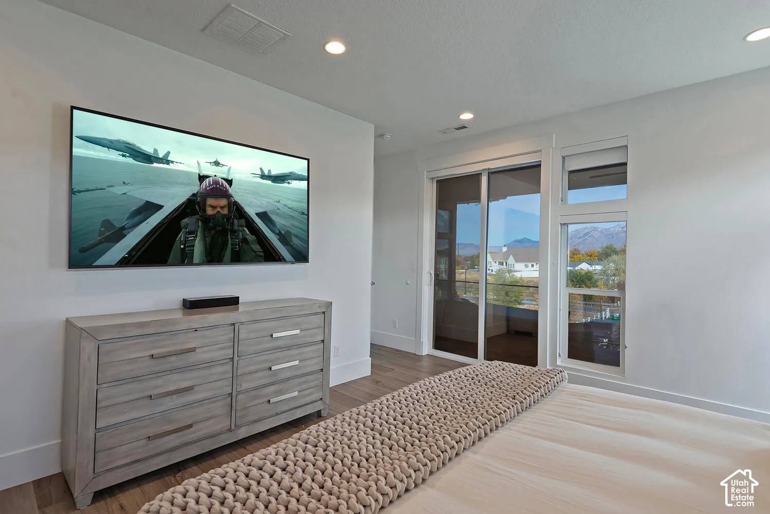 Recessed lighting, wood-finish flooring, and expansive glass sliding doors