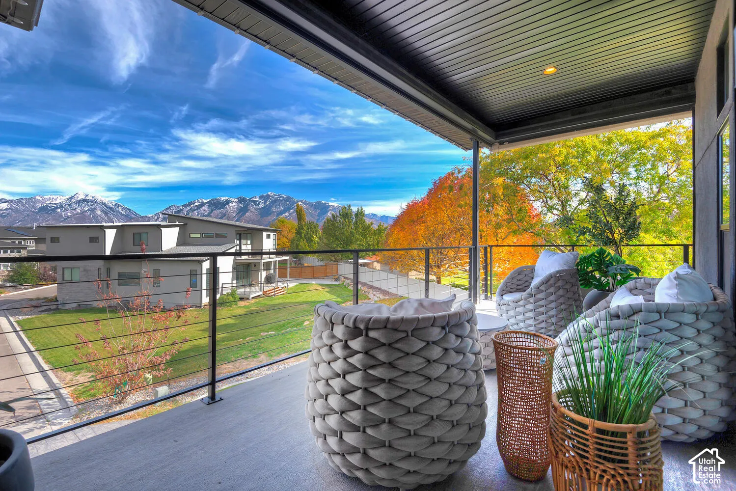 Covered balcony featuring wood-finish flooring, metal railing, and recessed ceiling lighting with mountain scenery