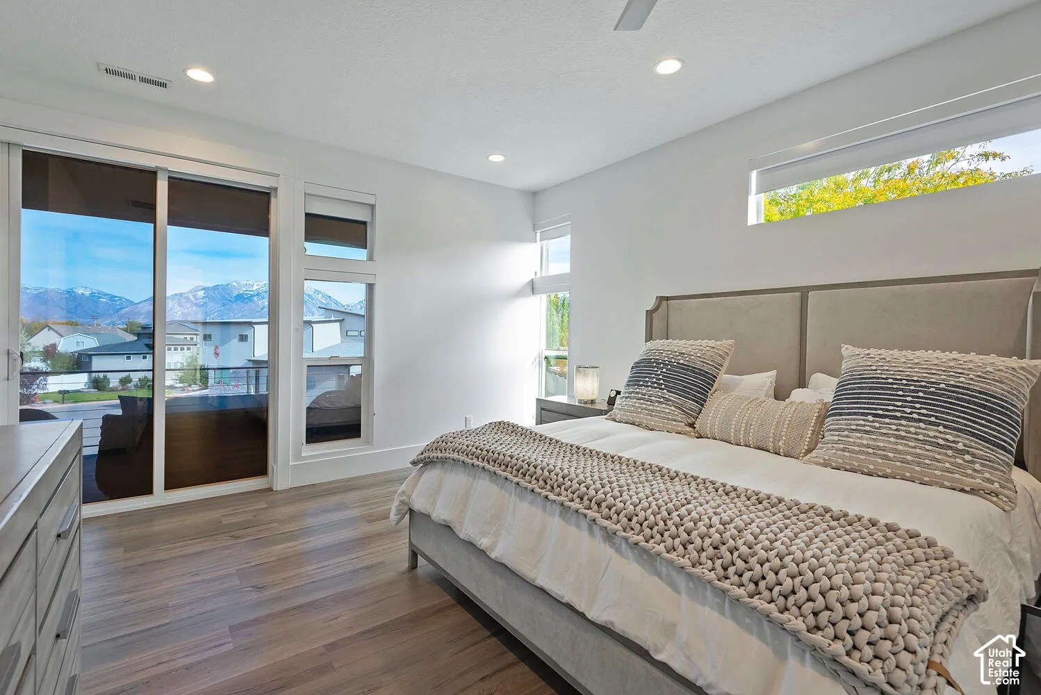 Wood-finish flooring, sliding glass door, recessed lighting, clerestory windows, and mountain scenery