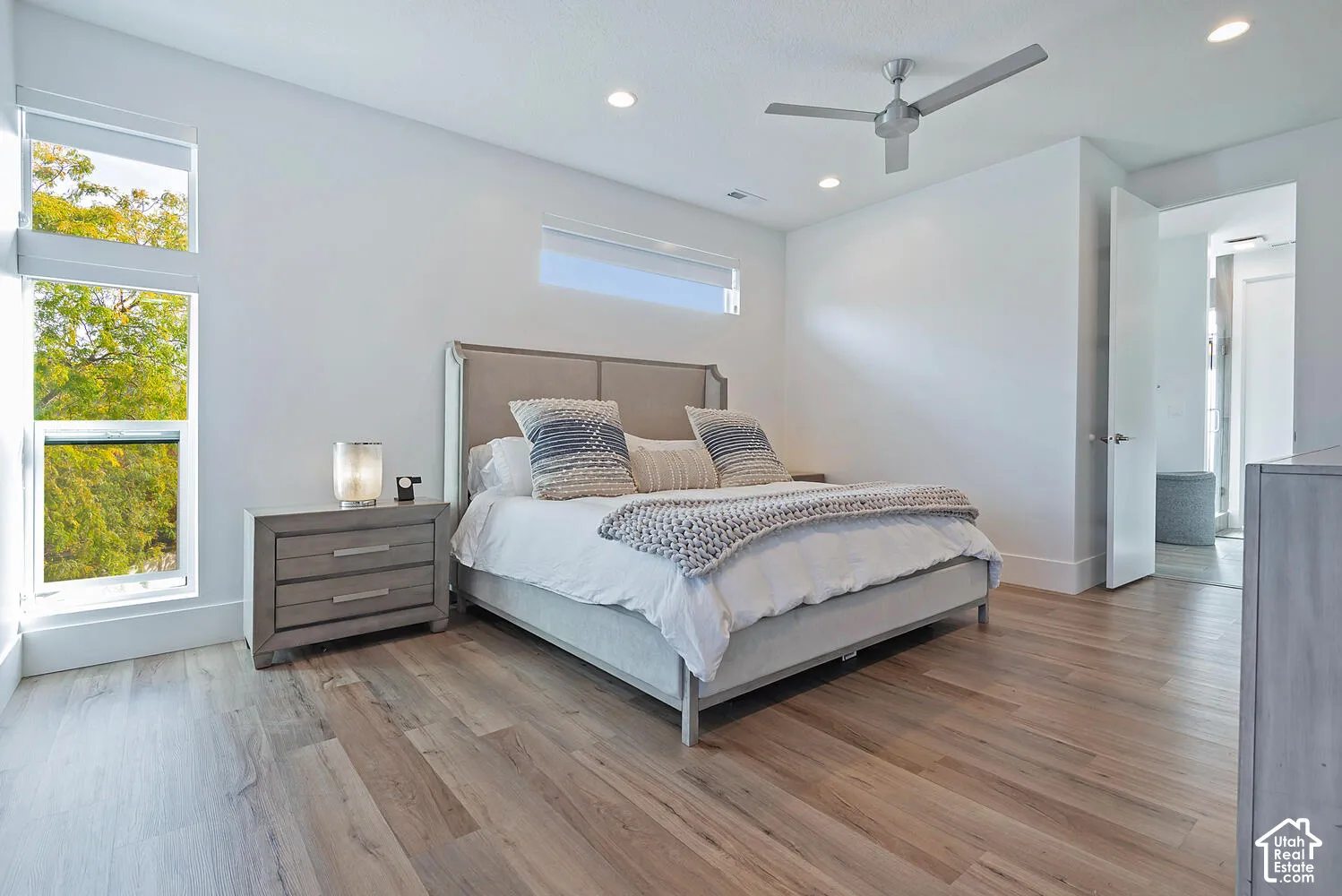 Wood-finish flooring, floor-to-ceiling windows, recessed lighting, and a modern metal ceiling fan