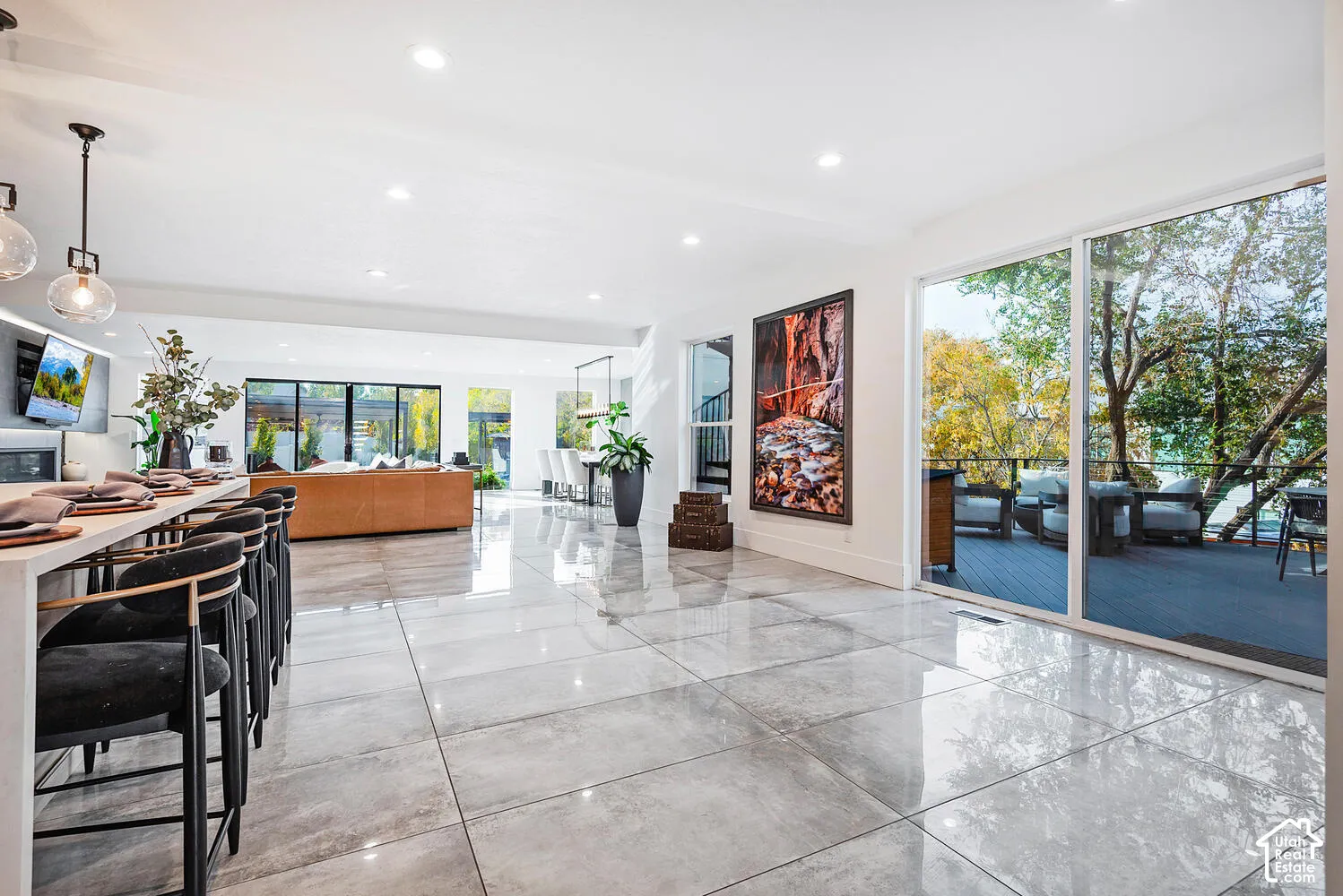 Large-format tile flooring, expansive glass sliding doors, recessed ceiling lighting, and pendant lighting fixtures