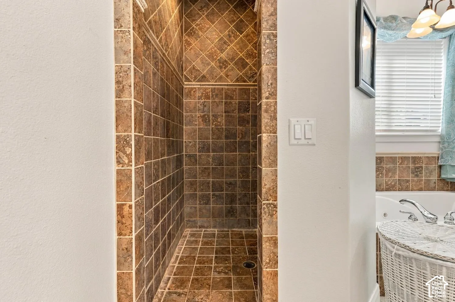 Walk-in shower featuring square tile surround with a diagonal tile accent pattern