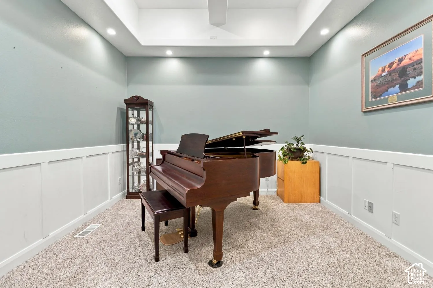 Tray ceiling featuring recessed lighting, complemented by wainscoting and wall-to-wall carpeting