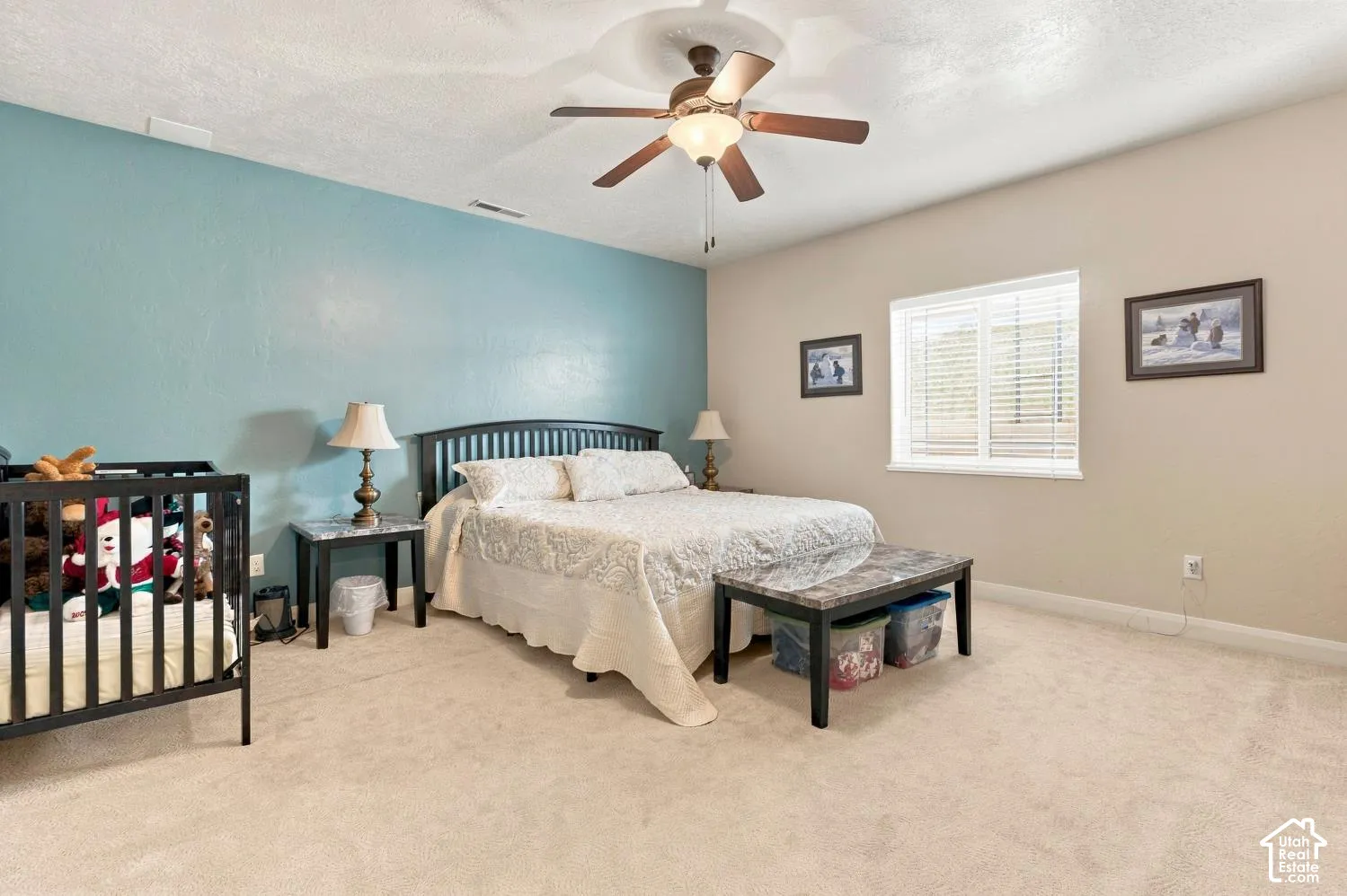 Spacious room featuring neutral carpeting, a dual-tone wall finish, and a ceiling-mounted fan with integrated lighting