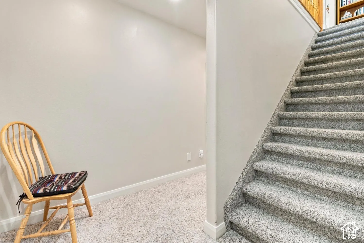 Staircase featuring neutral-toned carpeting and wood trim details
