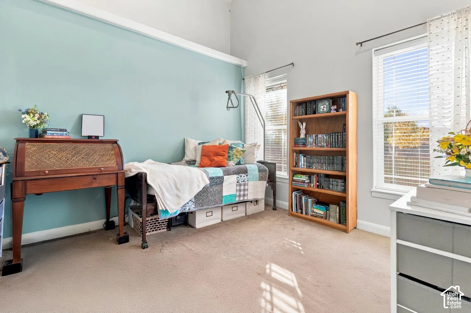 Vaulted ceilings, neutral carpeting, and large windows with horizontal blinds