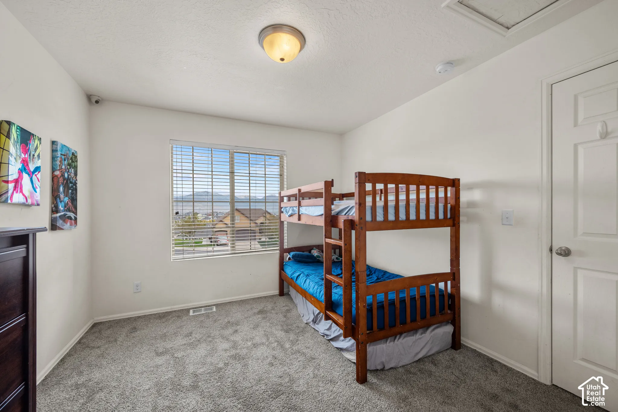 Interior room featuring neutral wall paint, wall-to-wall carpeting, a multi-pane window, and a ceiling-mounted light fixture