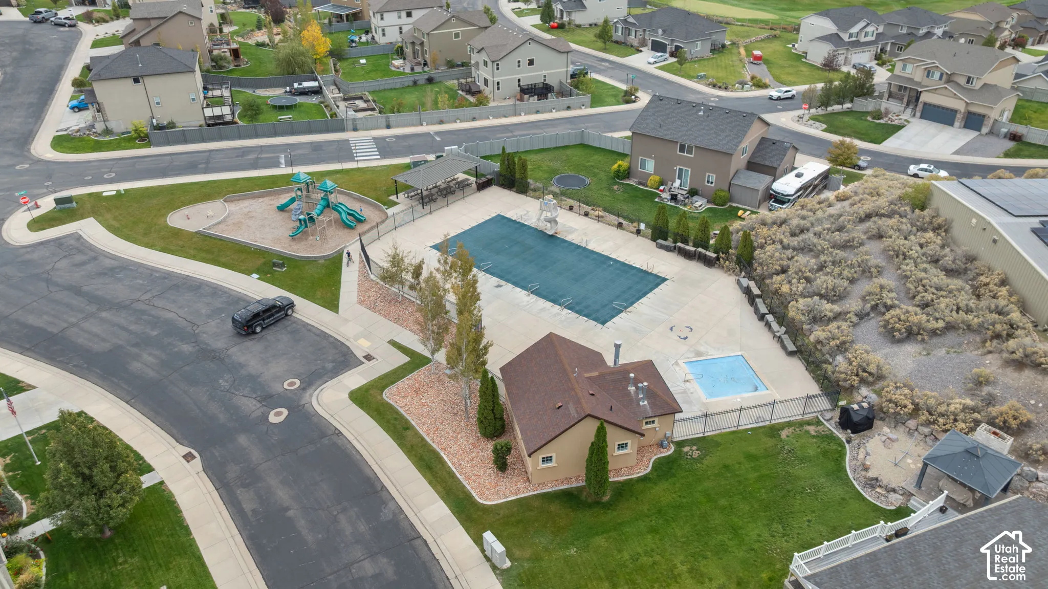Community recreation area featuring an outdoor swimming pool, spa, playground, covered pavilion, and clubhouse