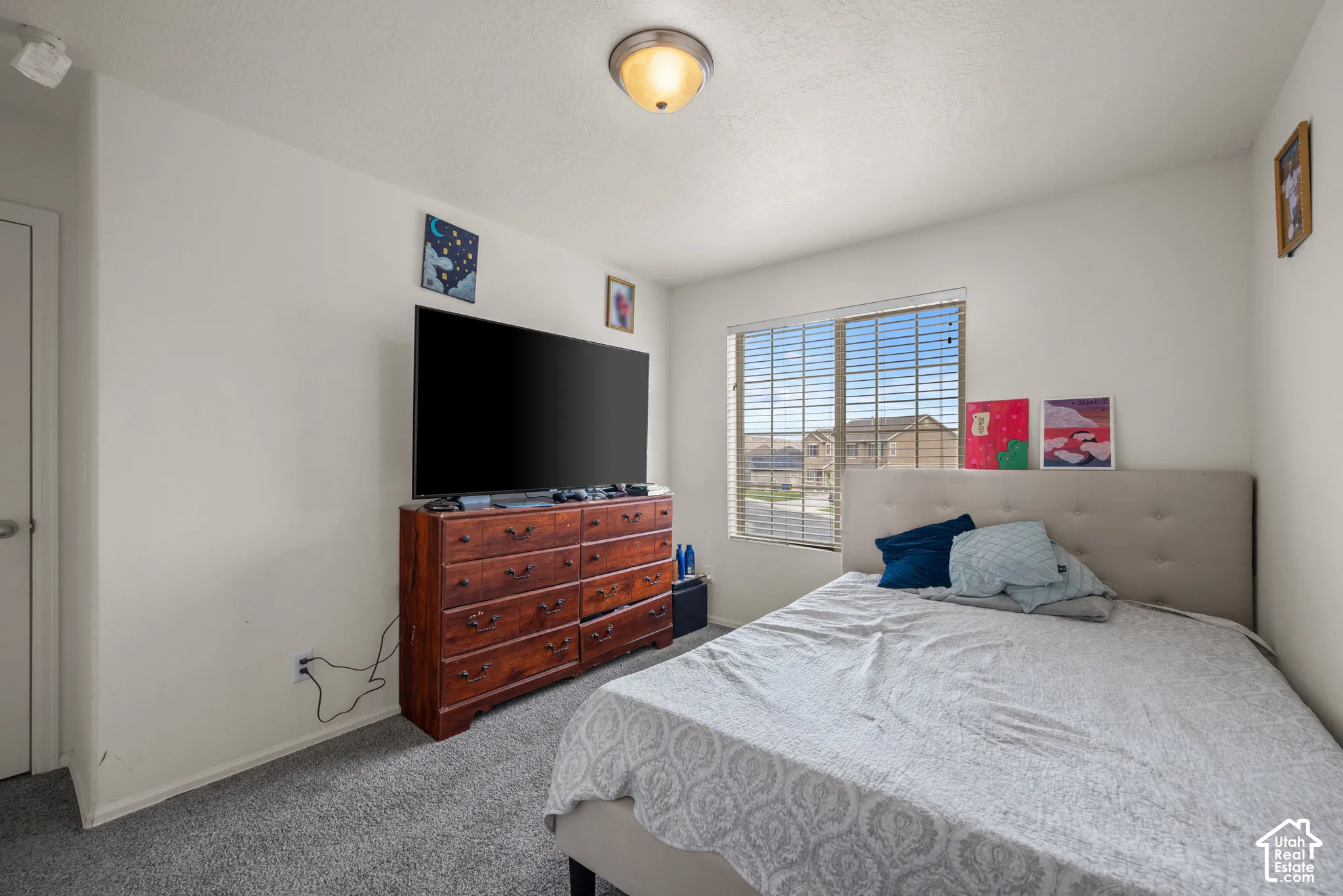 Neutral-toned interior space featuring neutral wall-to-wall carpeting, a multi-pane sliding window with horizontal blinds, and a dome-style flush mount ceiling light