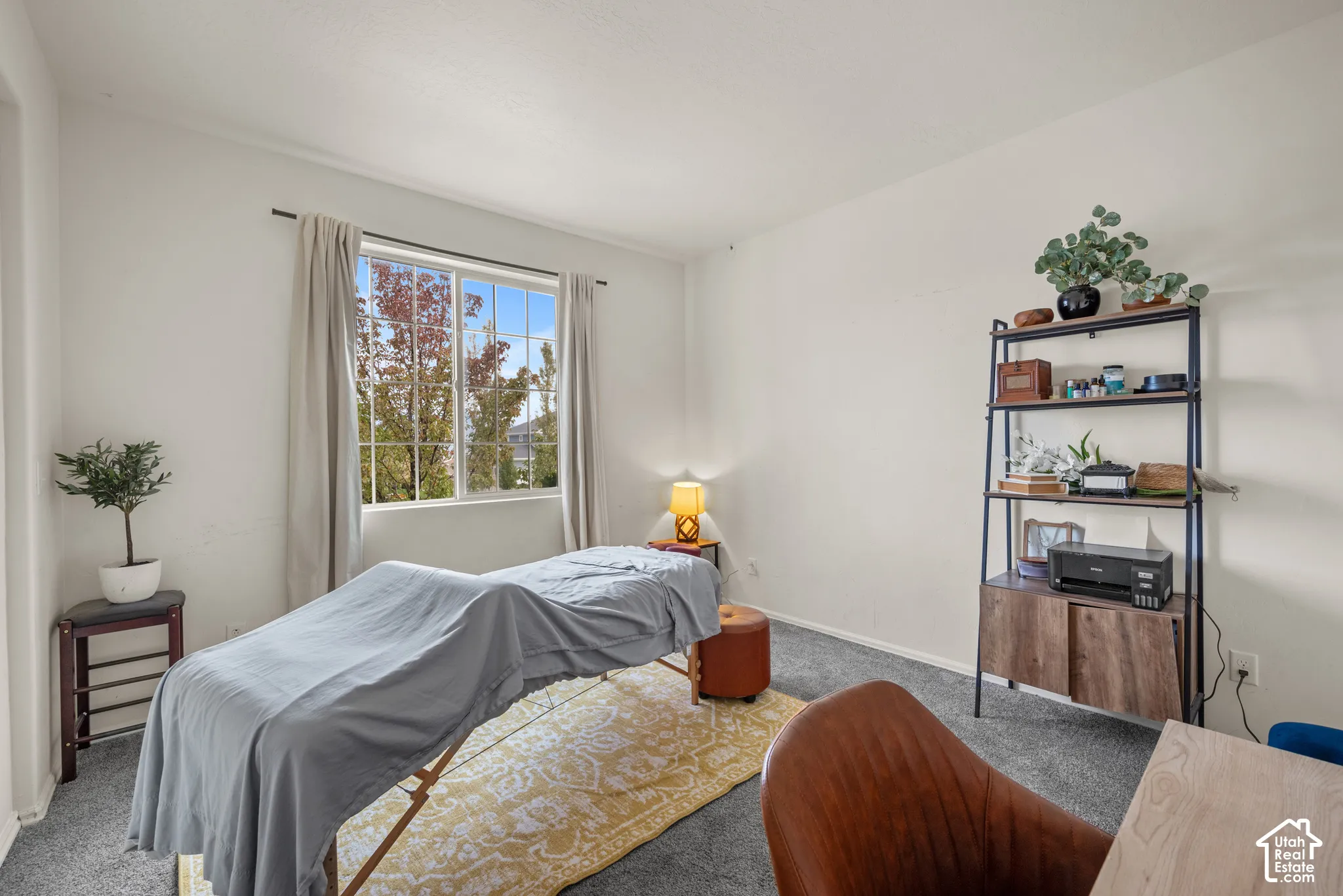 Neutral-toned room featuring carpeting, crisp white wall paint, and a large window with white-trimmed framing