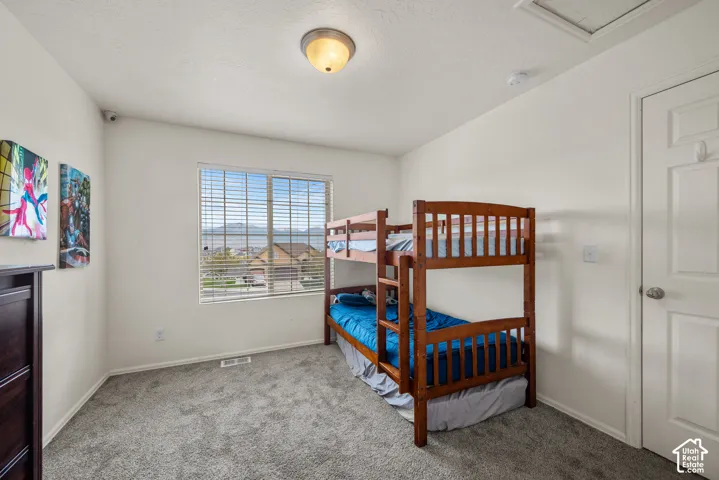Interior room featuring neutral wall paint, wall-to-wall carpeting, a multi-pane window, and a ceiling-mounted light fixture